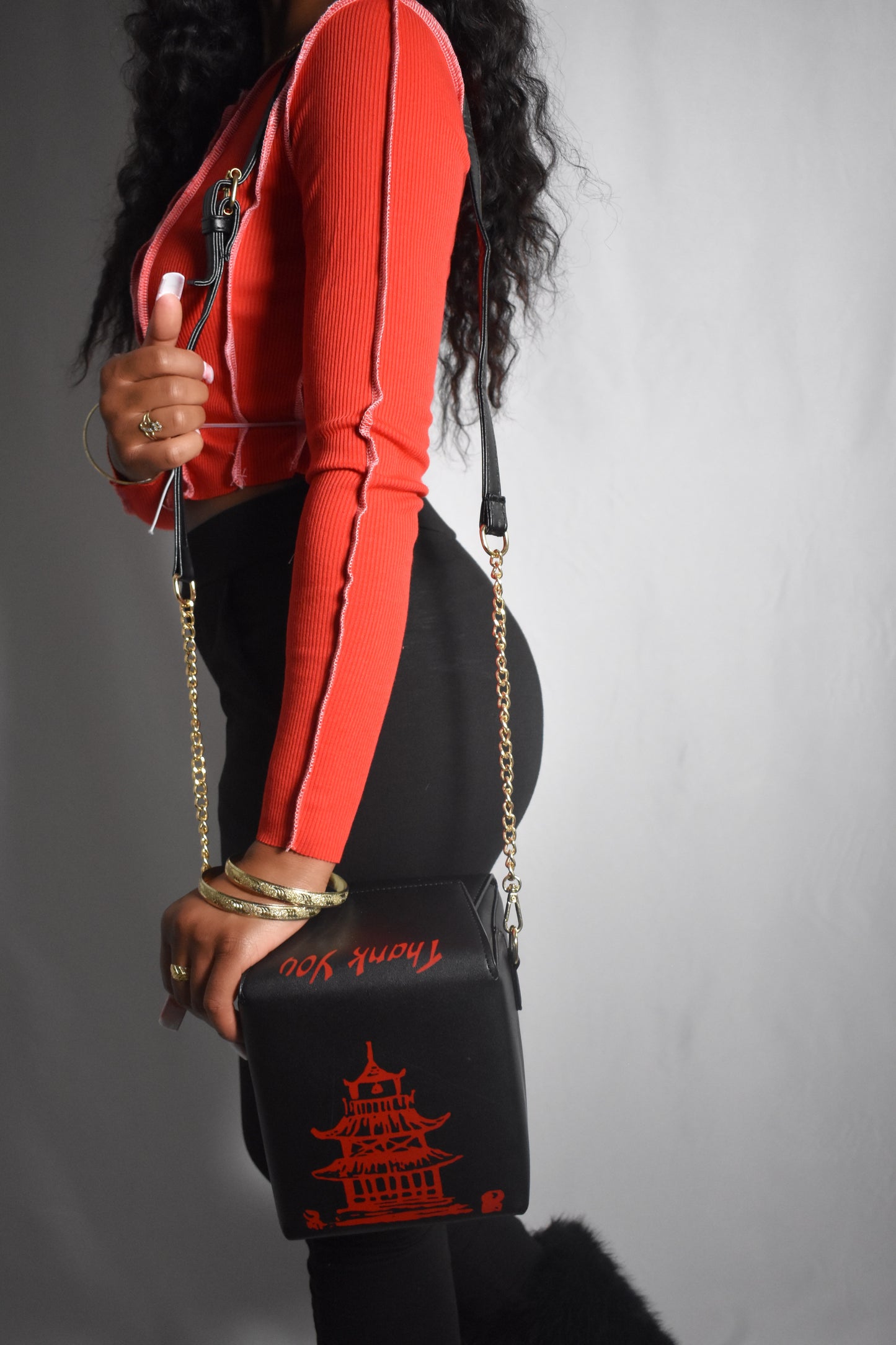 White bag with red pagoda design held by a person wearing a red outfit. Kawaii Kiss Asian takeout-style bag with tower illustration and ‘Thank You’ text.