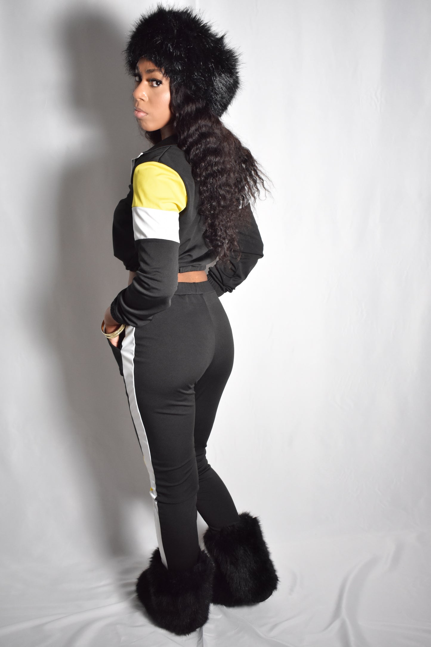 Black retro y2k tracksuit color block with yellow and white accents, brown faux fur boots, brown jumbo faux fur headband, two piece outfit set