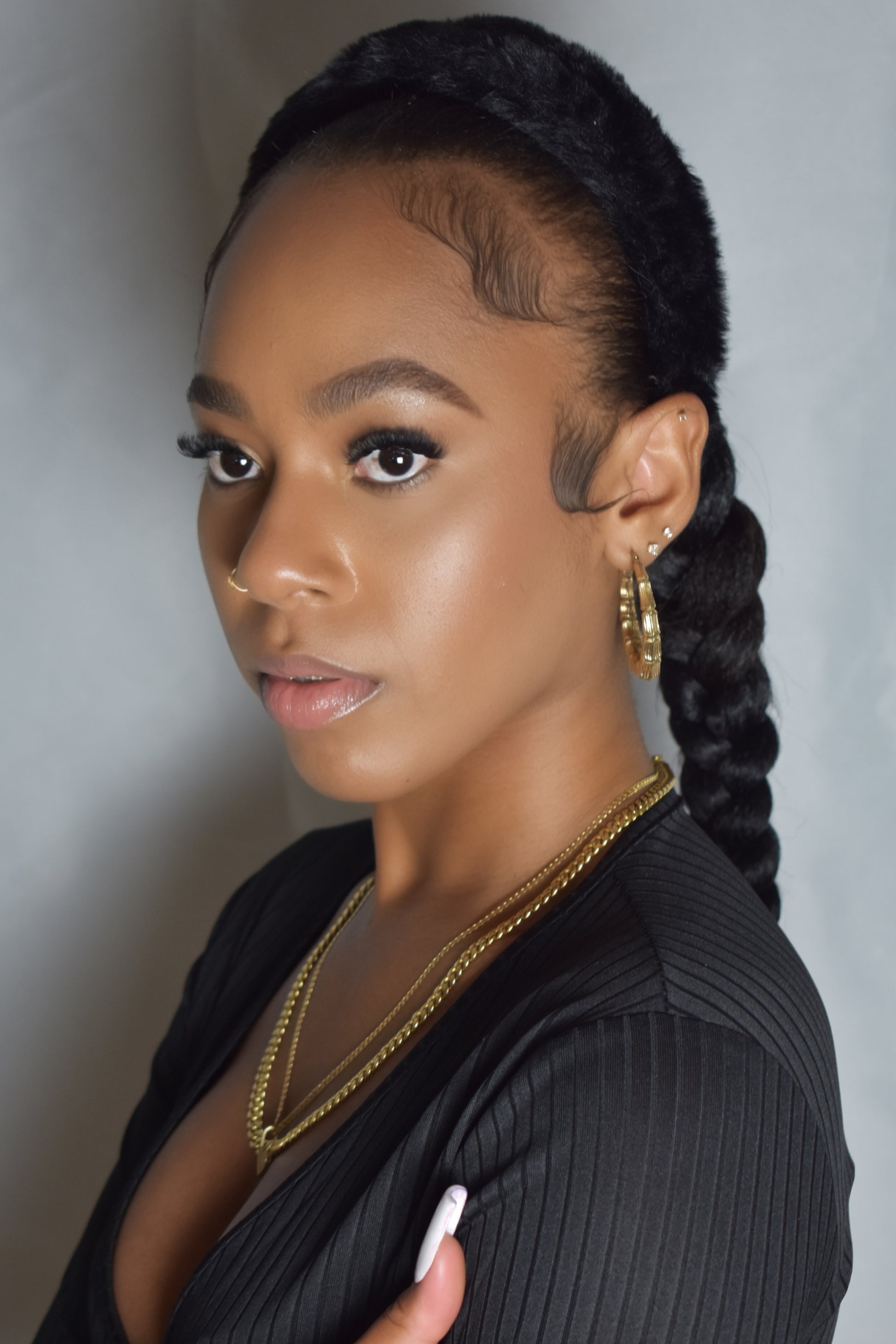 Woman with braided hair wearing a blue headband and gold jewelry. Snow Crown faux fur headband in soft plush material. Close-up of Snow Crown faux fur texture. Side view of furry Snow Crown headband with cozy fit. Snow Crown faux fur headband styled as cute Y2K winter accessory. Snow Crown faux fur headband available in multiple colors.