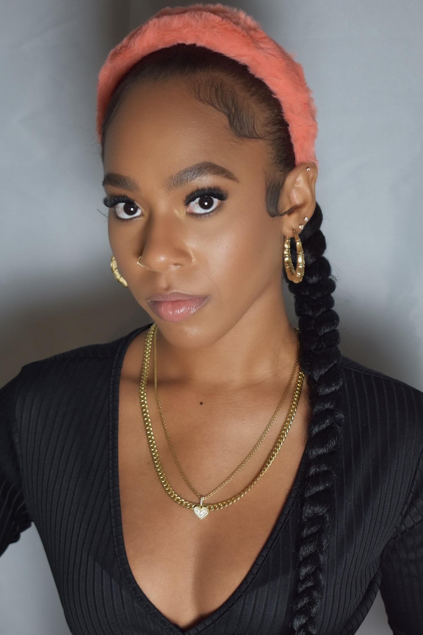 Woman with braided hair wearing a blue headband and gold jewelry. Snow Crown faux fur headband in soft plush material. Close-up of Snow Crown faux fur texture. Snow Crown faux fur headband styled as cute Y2K winter accessory. Snow Crown faux fur headband available in multiple colors.