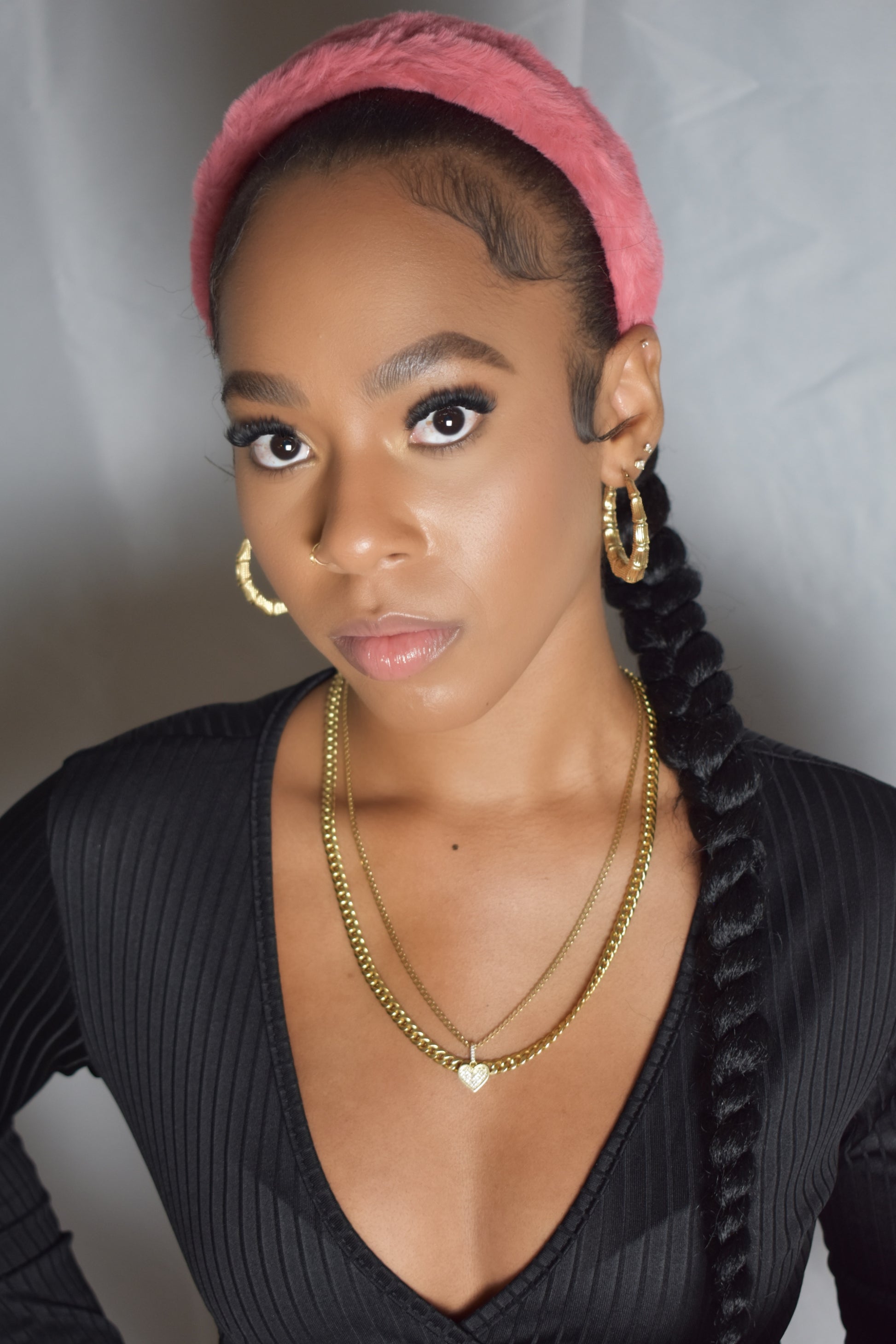 Woman with braided hair wearing a blue headband and gold jewelry. Snow Crown faux fur headband in soft plush material. Close-up of Snow Crown faux fur texture. Snow Crown faux fur headband styled as cute Y2K winter accessory. Snow Crown faux fur headband available in multiple colors.