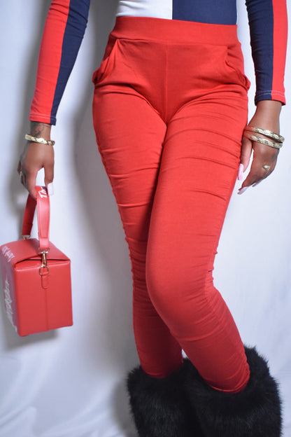 Model wearing red stacked pants with fitted silhouette. Black faux fur boots and kawaii kiss red Asian Chinese to go box handbag