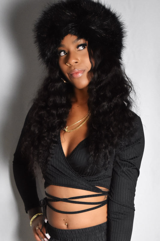 front view of black long sleeve wrap crop top with adjustable long tie crisscross strap strings and black jumbo faux fur headband