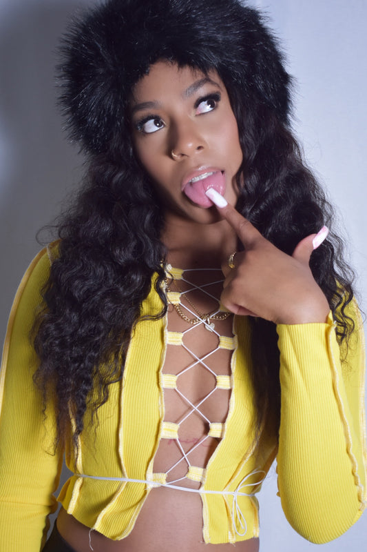 Front view of yellow Loose Strings top with laced-up front and tied string design, thick material and string detail, black jumbo faux fur headband